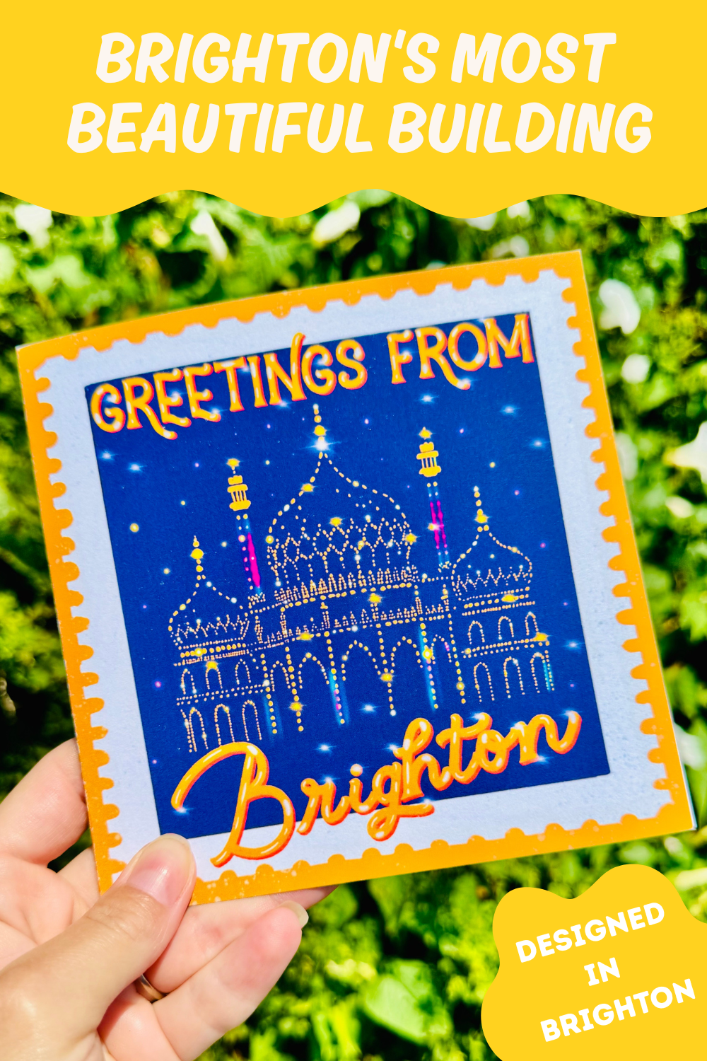 Postcard with 'Greetings from Brighton' design held by a hand against a green leafy background.