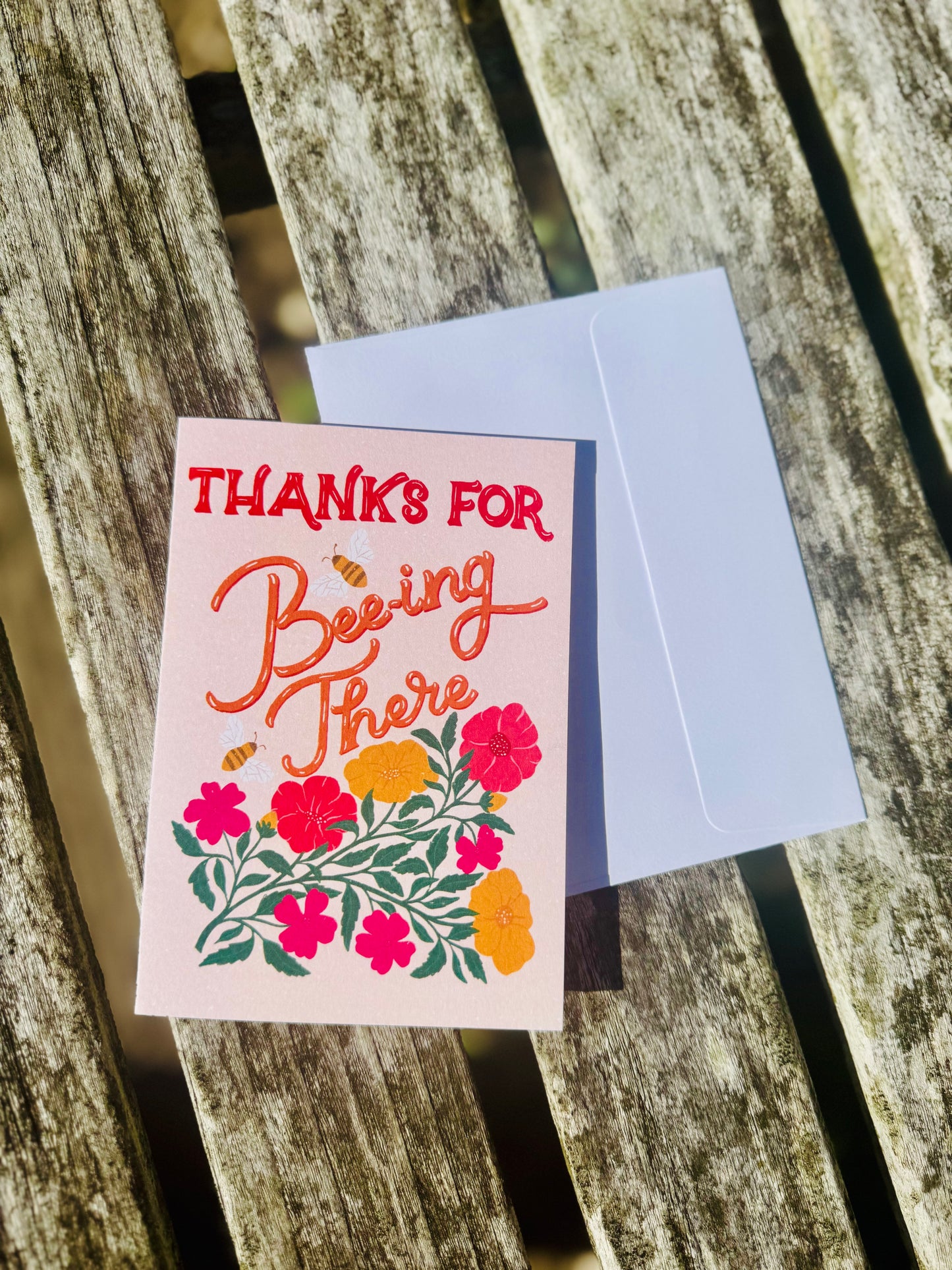 Greeting card with floral design and text on a wooden surface