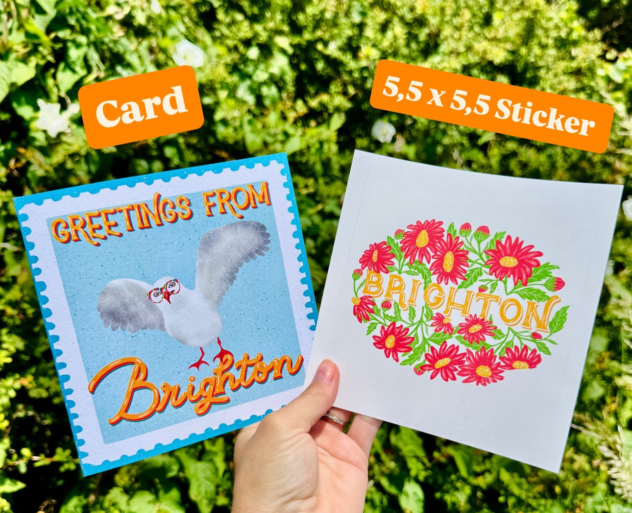 Hand holding a card and a sticker with floral design against a green outdoor background